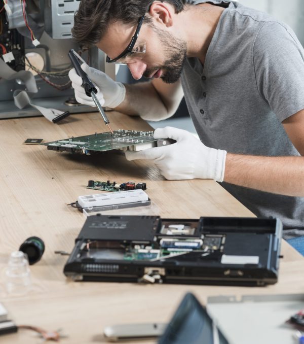 male-technician-repairing-computer-motherboard-wooden-desk